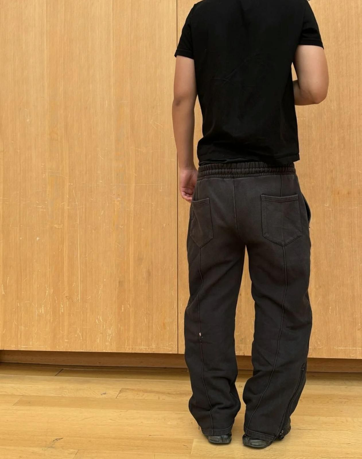 Men's black elastic waist sweatpants with drawstring, shown from the back, casual fit track pants.
