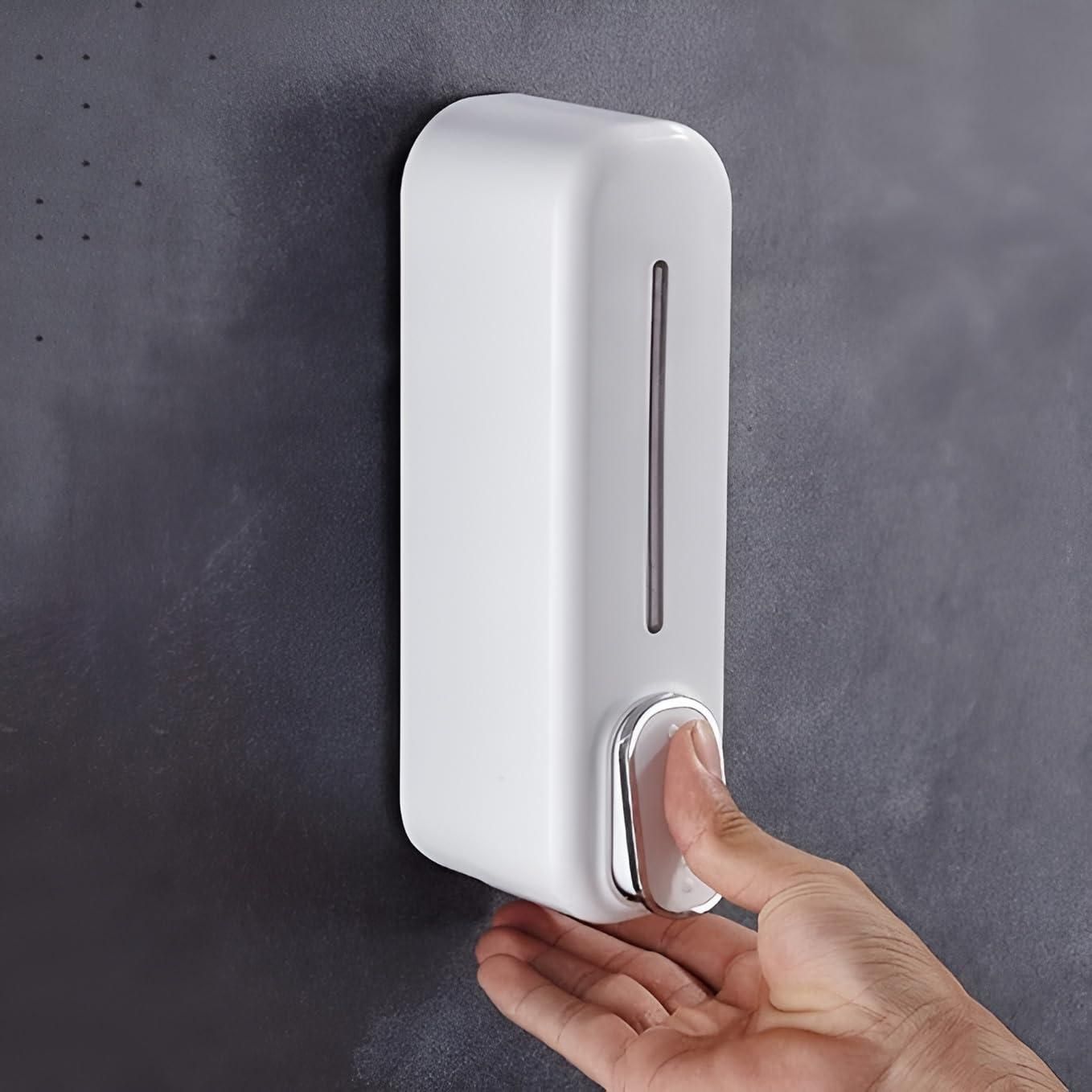 Wall-mounted manual soap dispenser in white plastic with press button and transparent level window