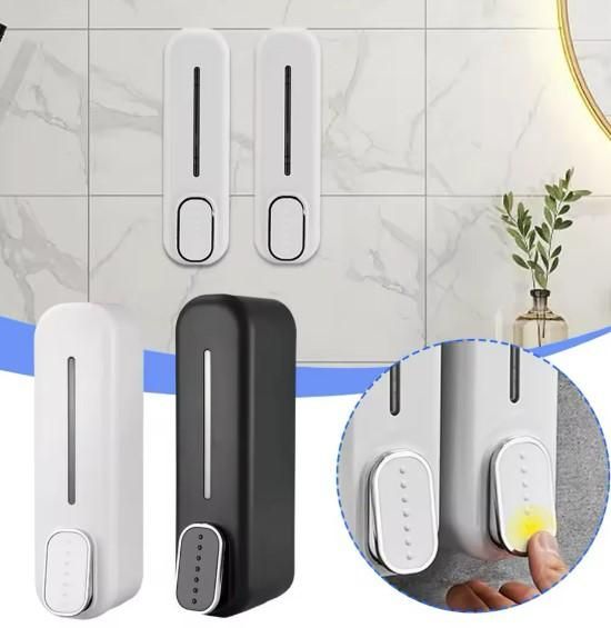 Wall-mounted manual soap dispenser in white and black plastic with a press button for easy use.