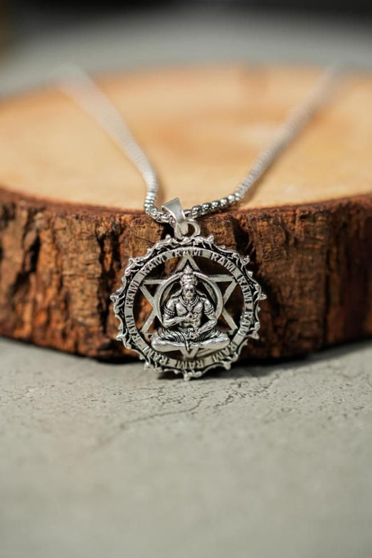 Silver oxidised stainless steel Shree Yantra with Hanuman Raksha pendant on chain displayed on wooden surface