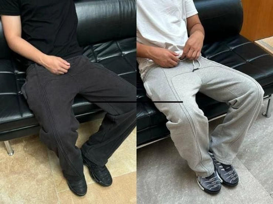 Men's elastic waist sweatpants with drawstring in black and grey colors, sitting on a black leather couch.